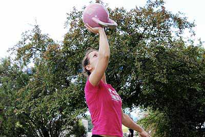 rózsaszín kettlebellt tartó nő